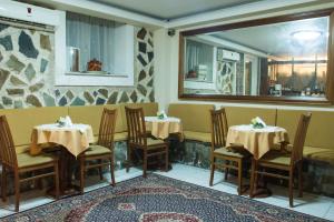 米蒂利尼Porto Lesvos hotel的餐厅设有2张桌子和椅子以及镜子