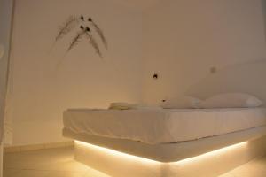 纳克索乔拉Naxian vacation with sea view的卧室配有一张墙壁上灯床。