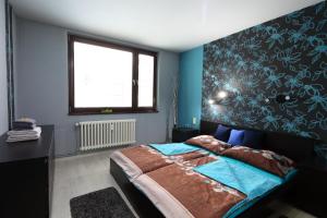 卢捷拿纳德德斯努Apartmán 77的一间卧室配有一张蓝色墙壁的床和一扇窗户