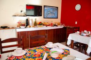 布希奥斯Pousada Luzes de Geribá的厨房配有2张桌子和红色的墙壁