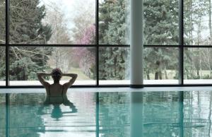 门希霍夫科尔豪斯马伦科罗恩酒店的坐在游泳池窗前的女人
