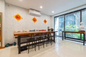河内豆腐之家公寓 - 一个叫做家的地方的厨房配有桌子和凳子,靠砖墙