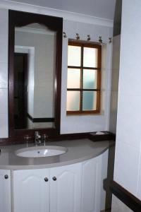 比勒陀利亚Kievits Kroon Gauteng Wine Estate的一间带水槽和镜子的浴室以及窗户。