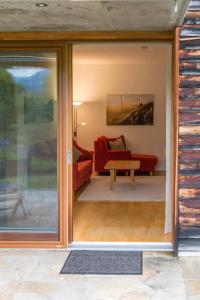 NötschGartenlodge Auszeit的客厅设有滑动玻璃门和红色沙发