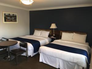尼亚加拉瀑布瀑布庄园度假酒店的配有两张床铺的酒店客房 - 带桌椅
