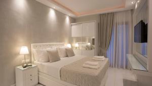 帕拉塔蒙Amaryllis Luxury Rooms的卧室配有白色床和毛巾