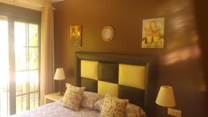 Estepona森特纳里欧酒店的卧室配有一张床,墙上挂着一个钟