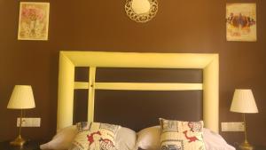 Estepona森特纳里欧酒店的一张带黑色和黄色床头板的床铺,配有两盏灯