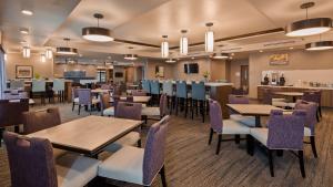 拉皮德城Best Western Plus Rapid City Rushmore的一间带桌椅的餐厅和一间酒吧