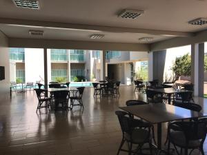 阿拉瓜伊纳Oásis Hotel的大楼内带桌椅的用餐室