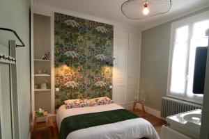 索米尔La Lambertine & Spa的一间卧室配有一张带花卉壁纸的床