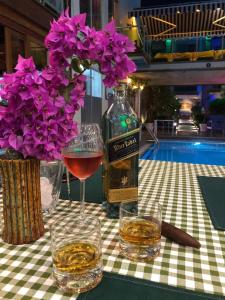 图尔古特雷斯Marin-A Hotel & Spa Turgutreis的鲜花桌子上的一瓶葡萄酒和玻璃杯