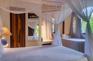 托兰克索Pousada Villa Bahia的一间卧室配有两张床、窗帘和窗户