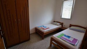 乌尔齐尼Familien Apartment Zeno的小房间设有两张床和窗户