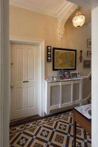 特鲁罗Cliftons Guest House的一条带白色门和图案地板的走廊