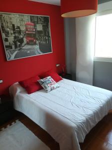 拉赫Apartamento A Atalaia的一间卧室配有一张红色墙壁的床