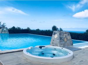 巴尼亚拉卡拉布拉Green Park Hotel & Residence的游泳池前设有按摩浴缸的游泳池