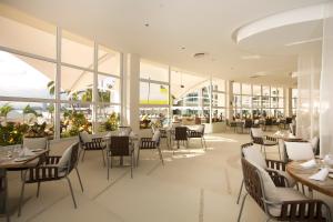 巴亚尔塔港Krystal Grand Puerto Vallarta - All Inclusive的餐厅设有桌椅和窗户。