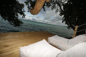 卢甘维尔希登湾生态度假酒店的两个白色枕头坐在水边的甲板上