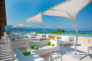 巴亚尔塔港Krystal Grand Puerto Vallarta - All Inclusive的庭院里摆放着一组白色的长沙发和椅子