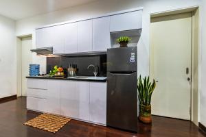 巴图Villa Mulyono 2的厨房配有白色橱柜和不锈钢冰箱