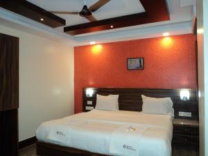 马杜赖Mani's residency的一间卧室设有一张红色墙壁的大床
