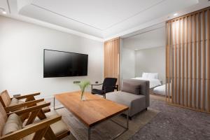 城南市SR Suites Bundang的带沙发、电视和床的客厅
