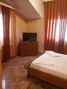 Băicoi帕拉勒拉45 旅游大厦旅馆的一间卧室配有一张床和一台平面电视
