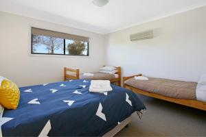 穆尔瓦拉Cypress Townhouse 11的一间卧室设有两张床和白色箭头的蓝色被子。