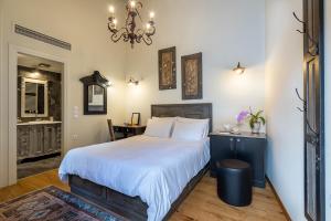 约阿尼纳古风酒店的一间卧室配有一张大床和一个吊灯。