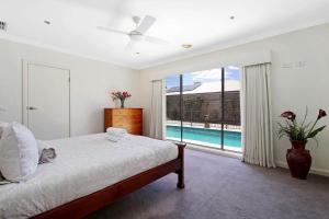 亚勒旺加The Grand Holiday House的一间卧室配有一张床,享有游泳池的景色