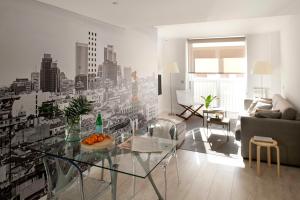 马德里艾瑞克沃科精品公寓 - 阿托查套房的客厅配有玻璃桌和城市壁画