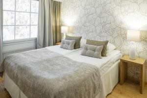 希内塔比尔旅馆拉普兰酒店 的一间卧室配有一张带两盏灯的大型白色床。