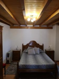 LavacolhosCASA TITA的一间卧室设有一张床和木制天花板