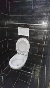 恩加帕鲁Bungalow Thaï vip jacuzzi interne的黑色瓷砖浴室内的白色卫生间