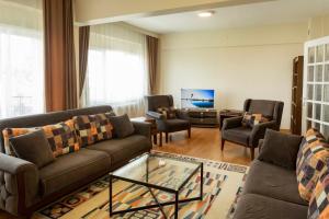 伯萨Vip Apart Hotel的客厅配有沙发、椅子和电视