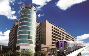 龟山乡福容大饭店桃园机场捷运A8的一座建筑前的铁轨上的紫色列车