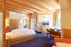塞尔瓦迪加尔代纳山谷康多尔酒店的酒店客房配有两张床和一张书桌