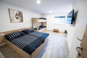 普雷德沃尔Guesthouse Urša的一间卧室配有一张床、一台电视和双层床。