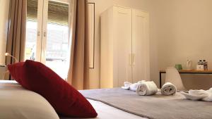 巴塞罗那拉帕尔梅拉旅馆的一间卧室配有一张带红色枕头和毛巾的床。