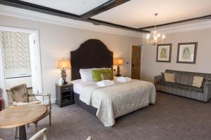 金斯林公爵黑德酒店的一间卧室配有一张床、一张桌子和一张沙发