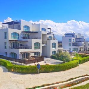 GhaziveranAphrodite Apartments North Cyprus的海滩上一座白色的大公寓楼