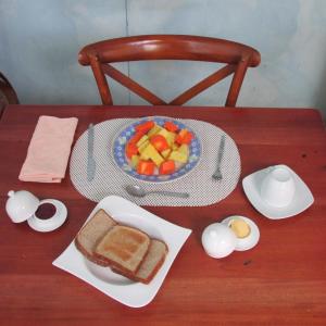 圣何塞Casa Leon Guesthouse的一张桌子,上面放着三明治和一盘水果