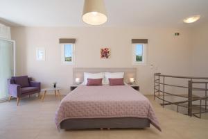 凯法利尼亚岛Rose Maisonette的一间卧室配有一张大床和一张紫色椅子