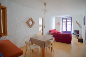 赫罗纳La Lleona Apartment的客厅配有桌子和红色沙发