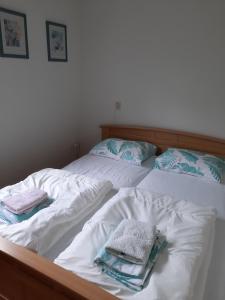 KrachtighuizenZonnig zomerhuis的一张带白色床单和毛巾的床