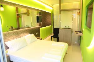 苏达Oneiro Suites的卧室配有白色的床和绿色的墙壁