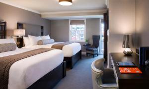 纽波特福缇1诺瑟酒店的酒店客房配有两张床和一张书桌