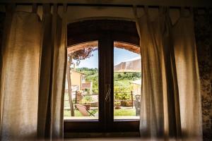 蒙泰斯库达伊奥Casetta Luna e Sole的窗户配有窗帘,享有庭院的景致
