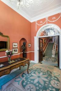 都柏林海灵顿大厅酒店的客厅设有橙色的墙壁和楼梯